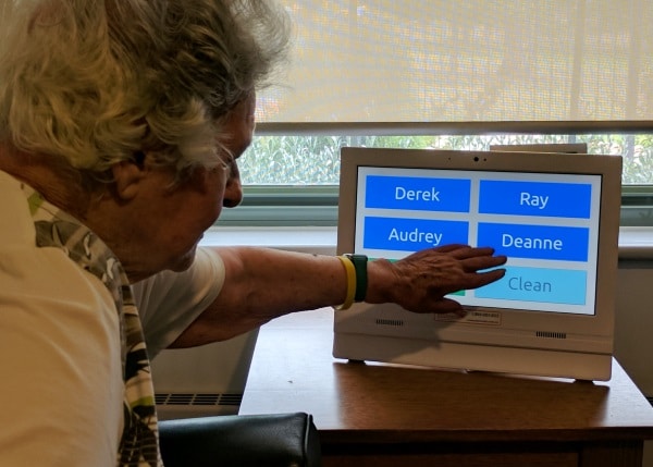 ผู้หญิงสูงอายุใช้ Konnekt Seniors Videophone USA ปุ่มโทรออกสัมผัสเดียว