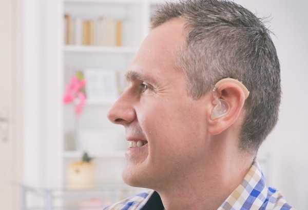 Man with hearing aid working from home