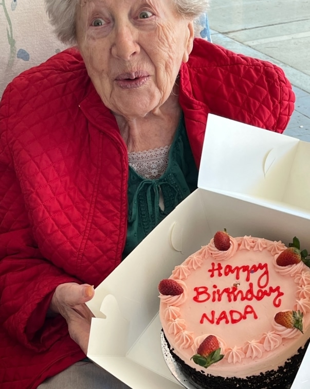 Nada pokazuje swój tort urodzinowy w swoje 93. urodziny, które obchodziła nad nią Konnekt Videophone z napisami