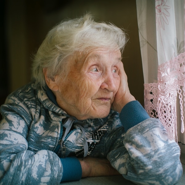 Elderly lady who has dementia, looking out a window