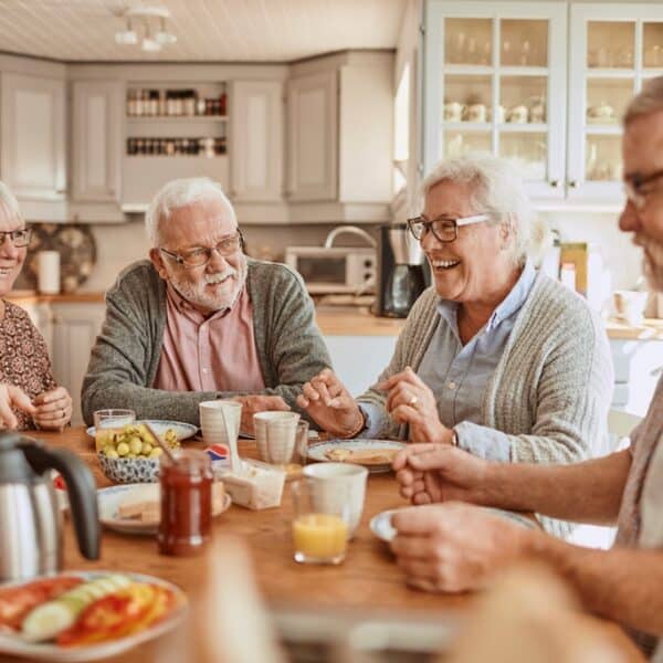 Patru adulți în vârstă care mănâncă împreună