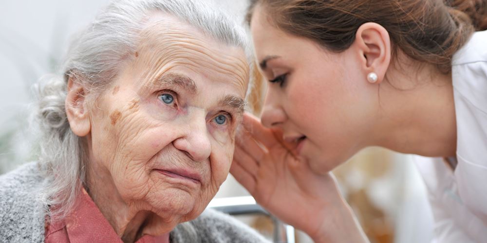 Lady with hearing loss trying to listen to her nurse