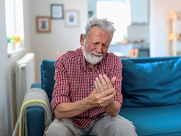 Man massaging his arthritic hand and wrist